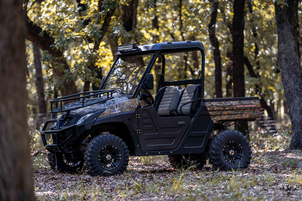 Camouflage HuntVe Game Changer 4x4 electric UTV with light bar parked in the woods. Image via Metro Golf Cars.